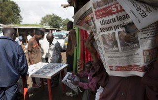A man reads the morning edition of a newspaper showing provisional results for the two main presidential election contenders in the Kibera slum of Nairobi