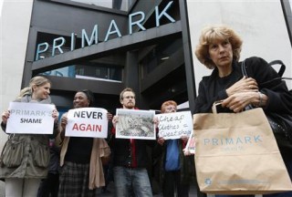 A shopper passes demonstrators outside clothing retailer Primark in central London