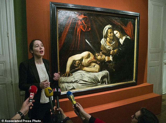 Julie Ducher, French expert specialized in old master paintings, talks to the media in Paris, Tuesday, April 12, 2016 next to a painting that might have been executed by Italian master Caravaggio. The painting could be worth more than 100 million euros has been found in an attic in Southern France.The picture, whose authenticity has not been established, had been left for more than 150 years in a property in the outskirts of Toulouse. (AP Photo/Michel Euler)